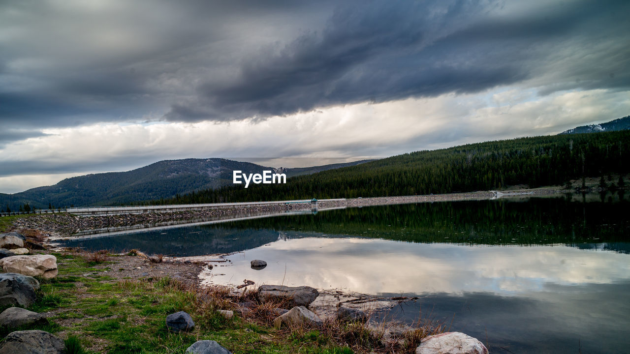 SCENIC VIEW OF LAKE BY MOUNTAIN AGAINST SKY