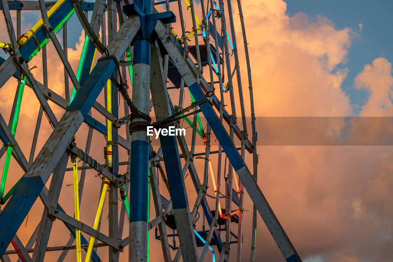 Close-up of cropped ferries wheel against clouds