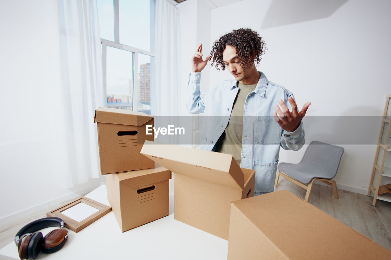 Man looking at cardboard boxes at home