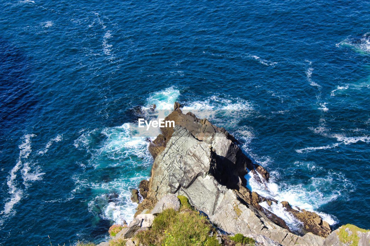 HIGH ANGLE VIEW OF ROCK FORMATION AT SEA