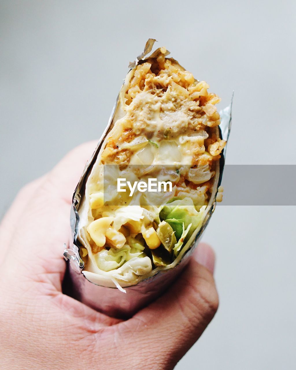 Close-up of cropped hand holding burrito