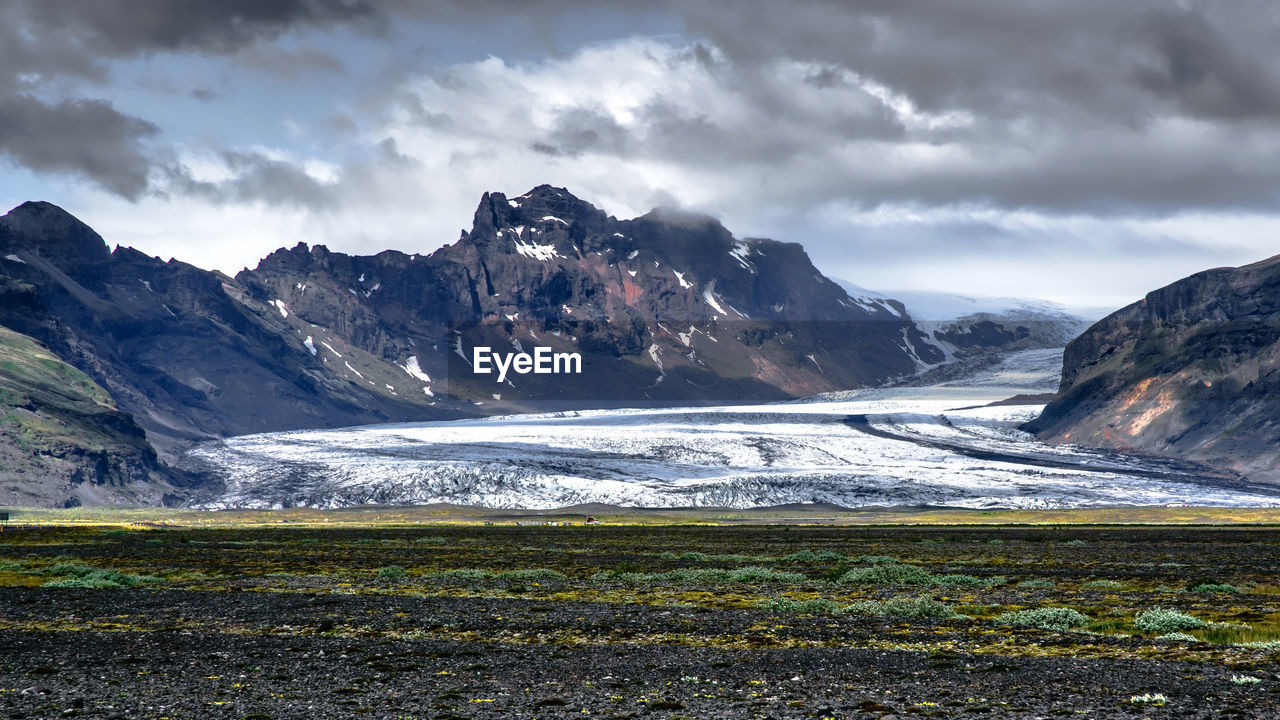 Scenic view of mountains against cloudy sky