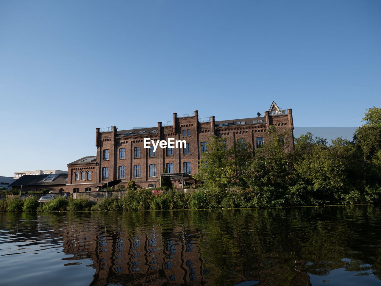 BUILT STRUCTURE BY LAKE AGAINST SKY