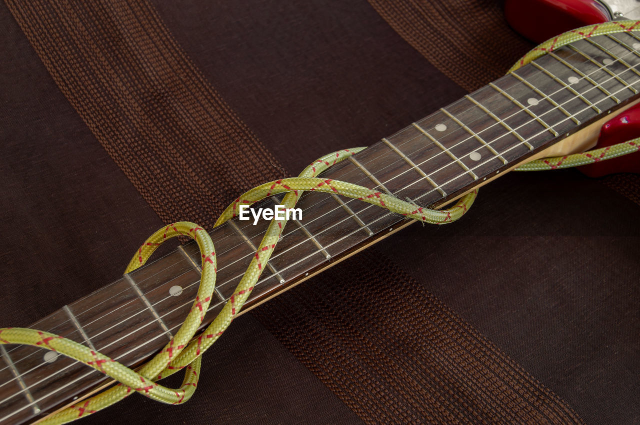 High angle view of interconnect plug and guitar on table