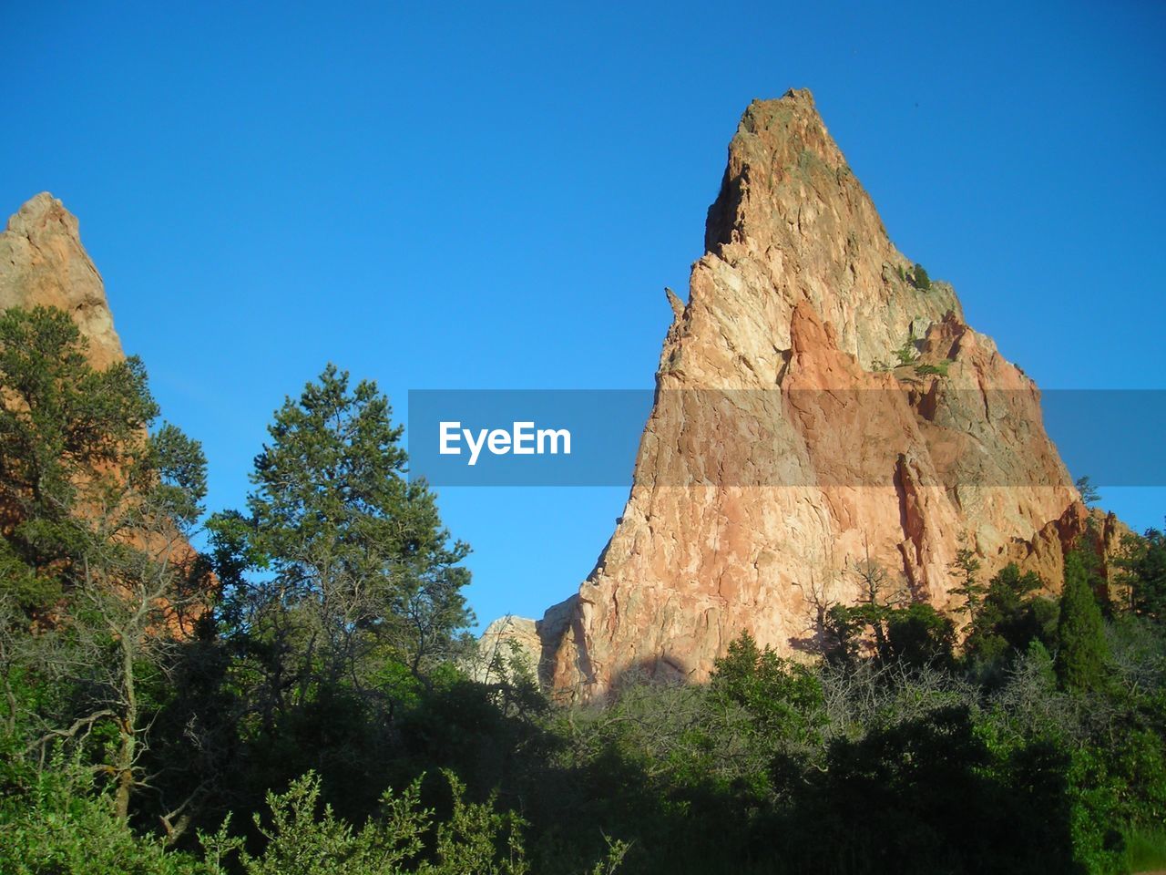 Low angle view of rock formation against clear blue sky