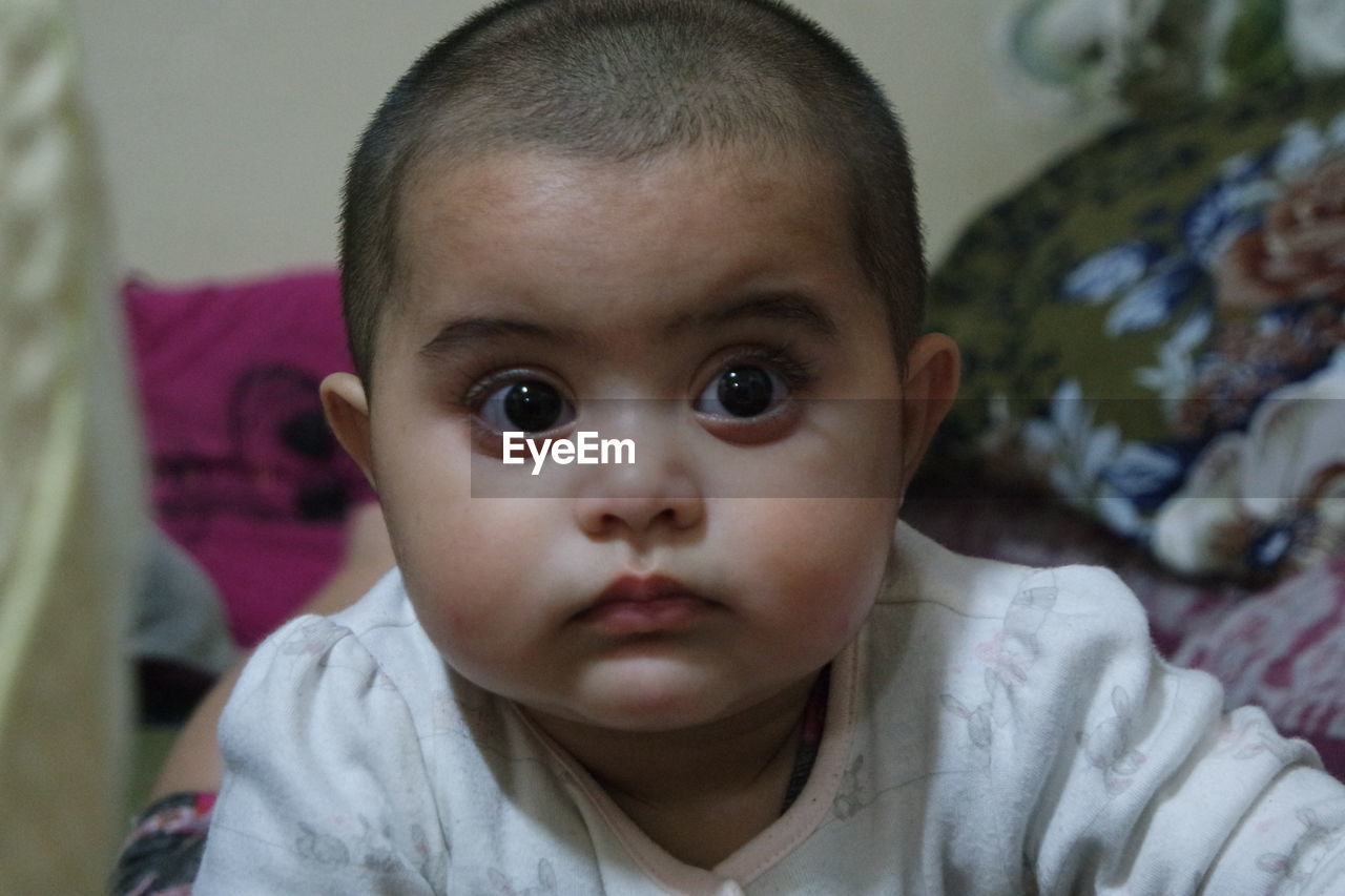 Portrait of cute baby lying on bed