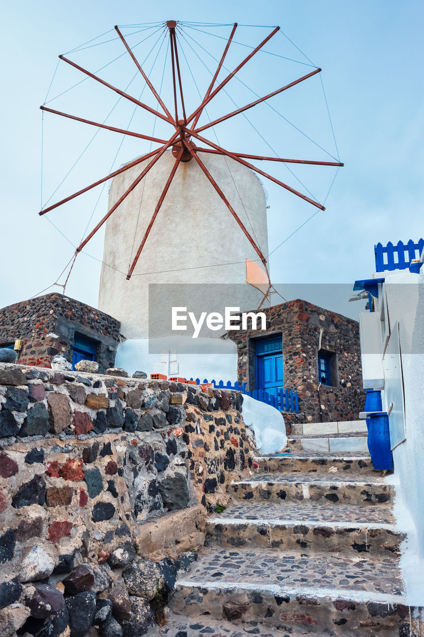 Old greek windmill on santorini island in oia town with stairs in street. santorini, greece