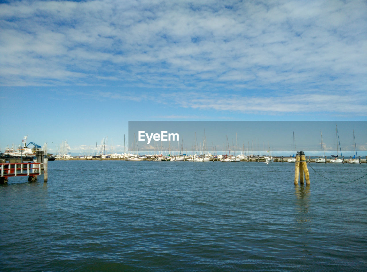 Sailboats in sea against sky