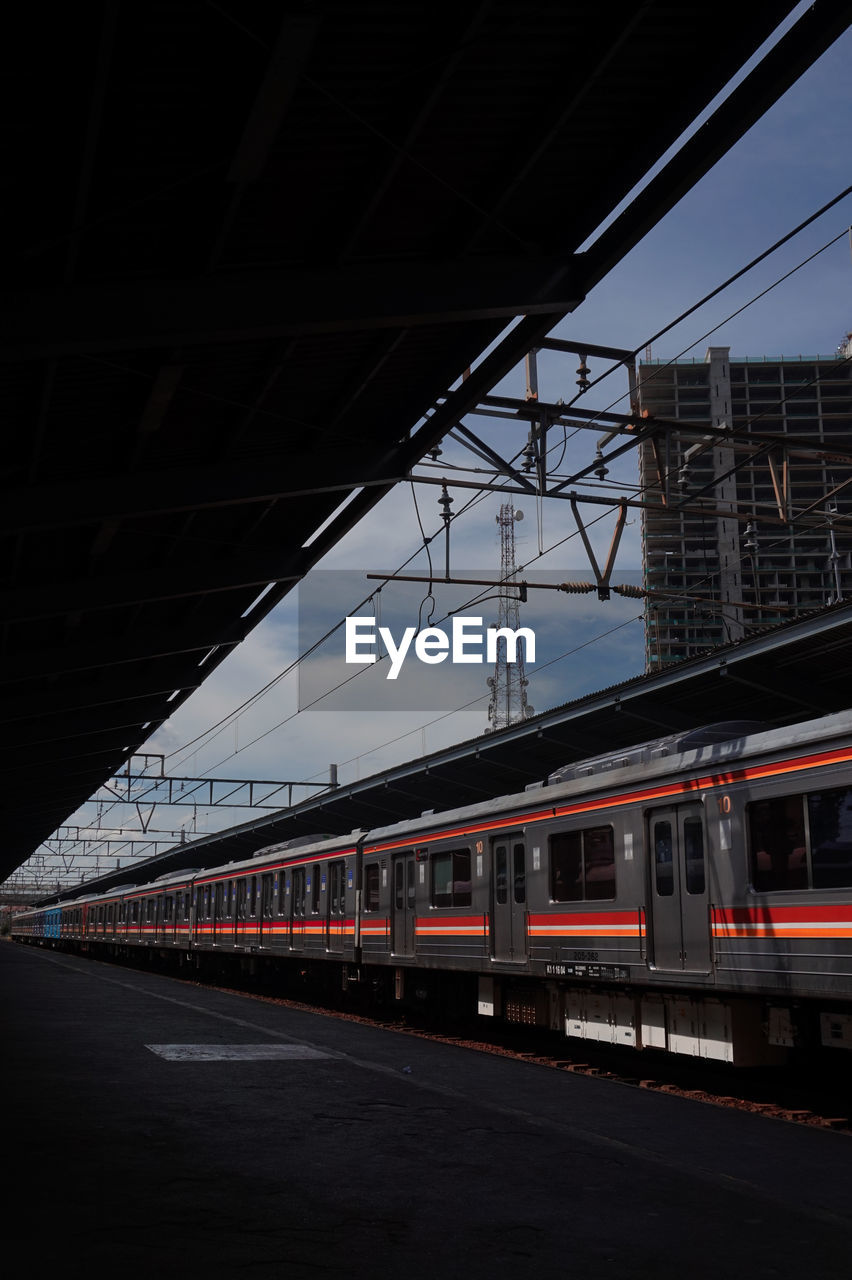 Train at railroad station in city during sunset