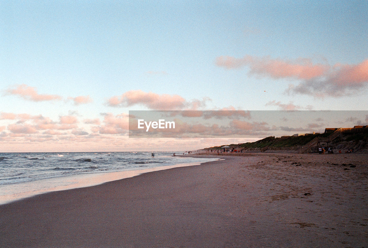 scenic view of beach against sky at sunset