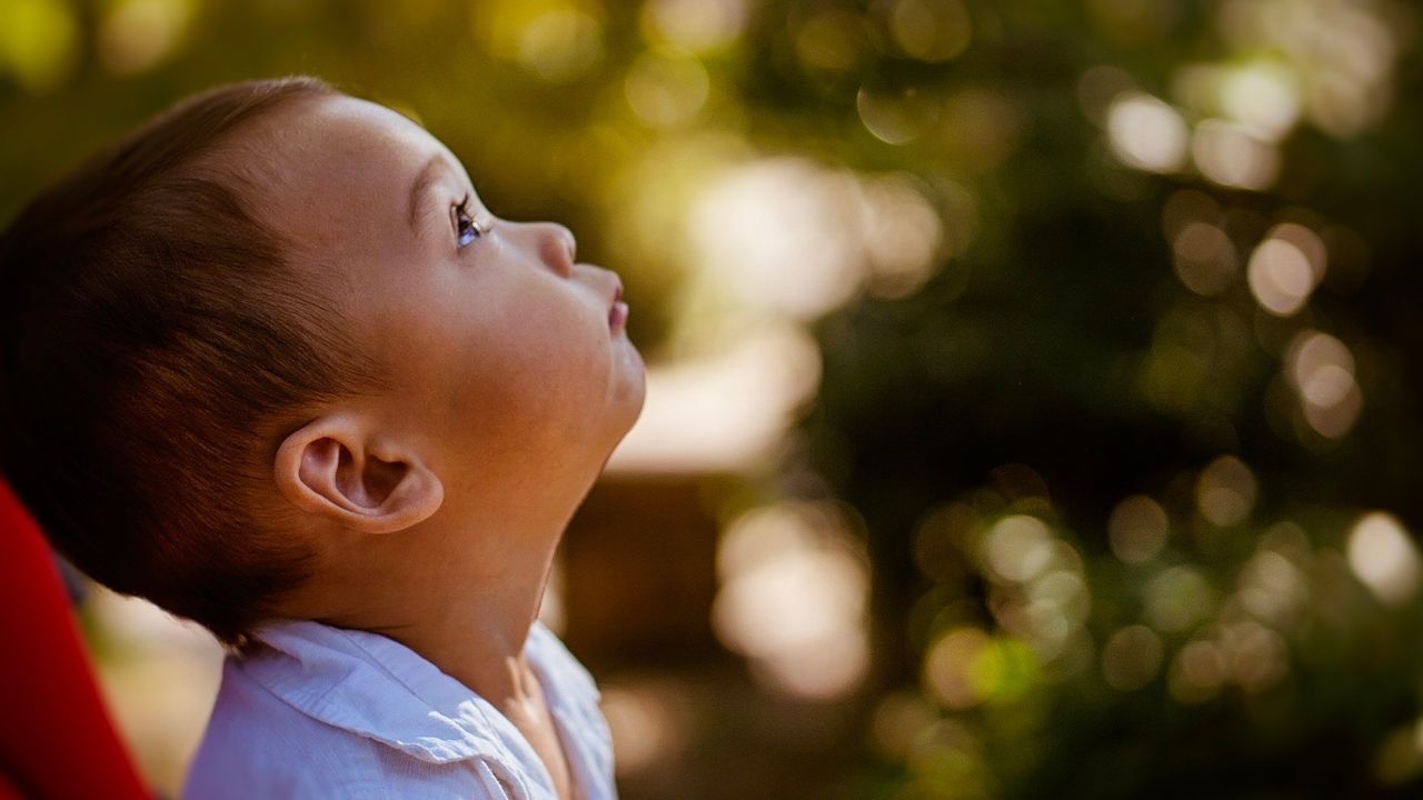 Side view of baby boy looking up