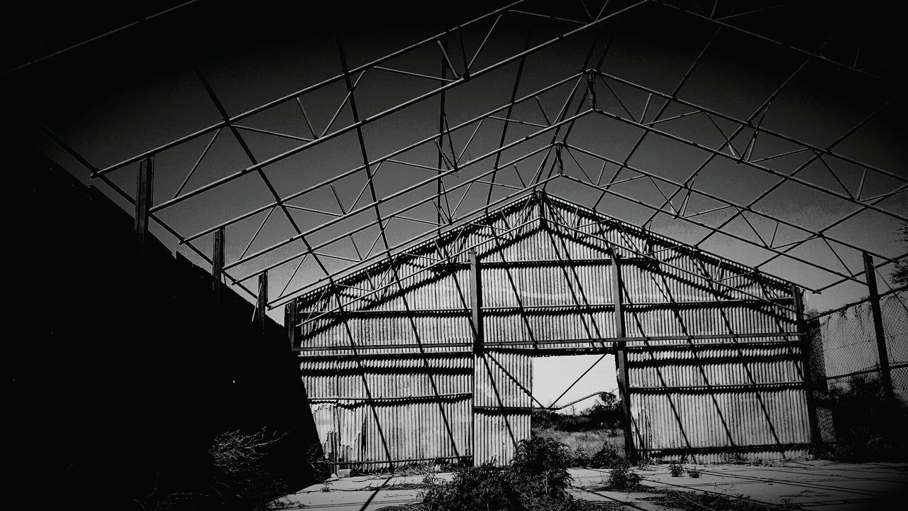 LOW ANGLE VIEW OF BUILT STRUCTURE AGAINST SKY SEEN THROUGH GLASS