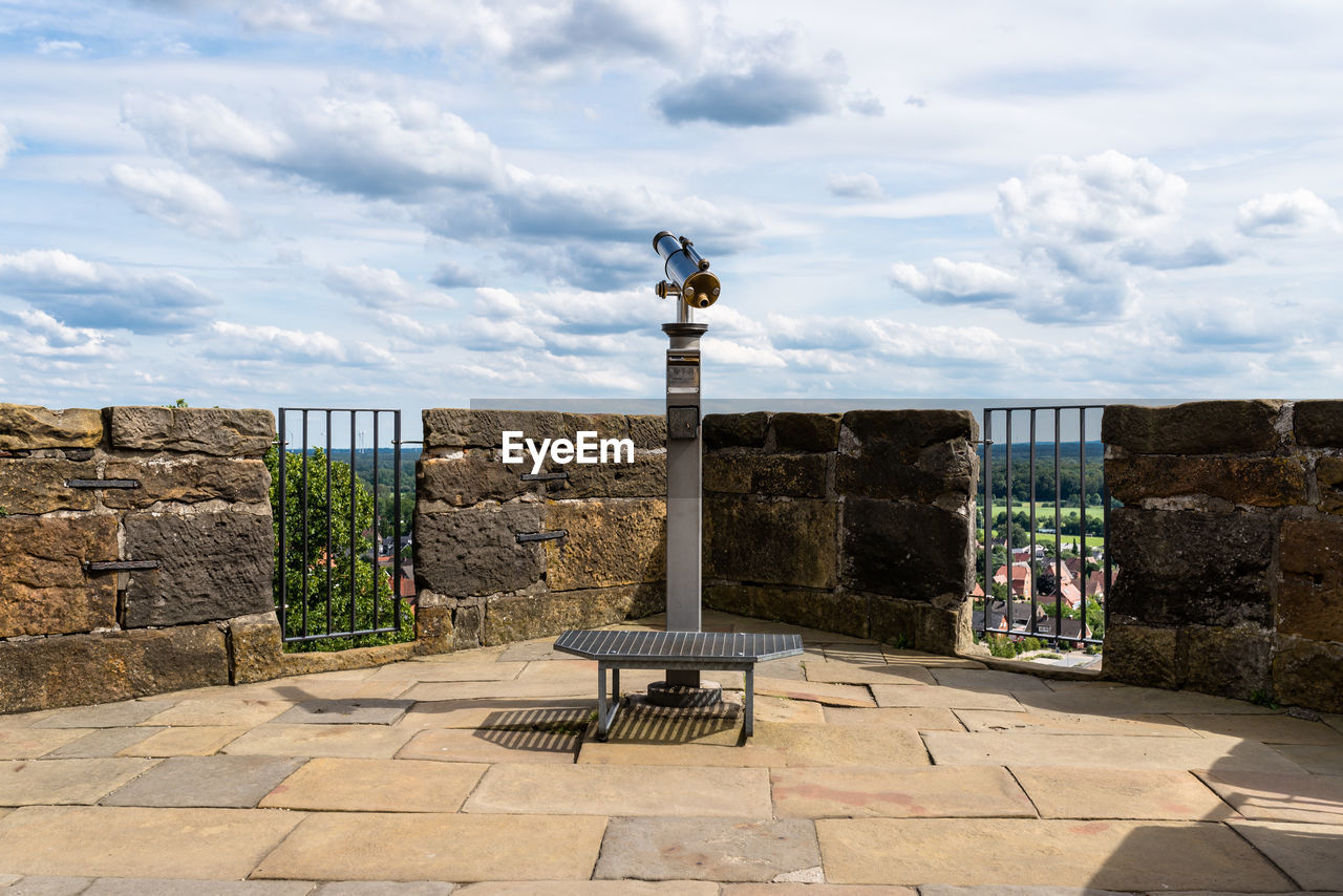 Paid single lens telescope, set on a high vantage point with a view of the city.