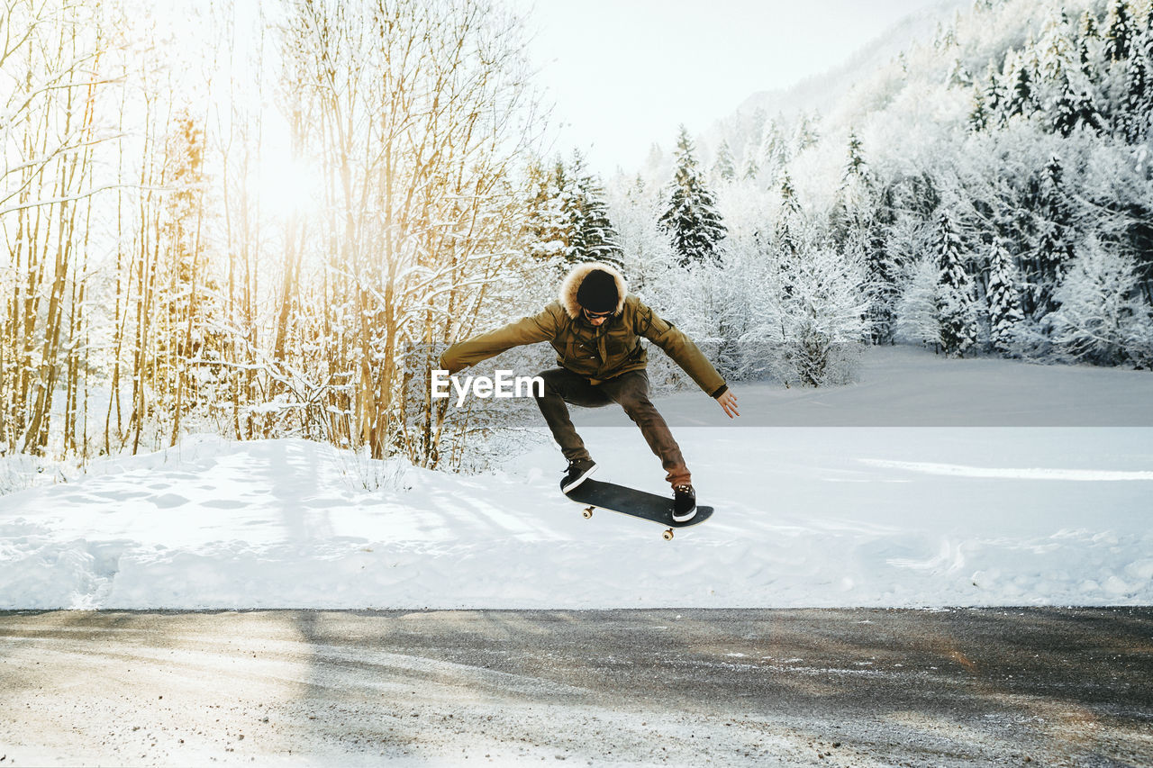 Man in mid-air skateboarding over road