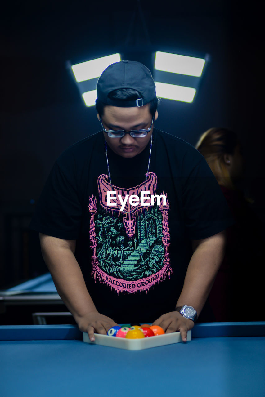 portrait of young man playing pool table