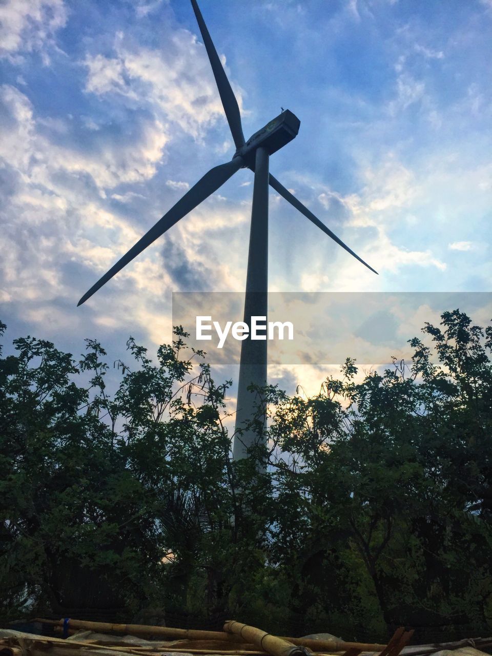 LOW ANGLE VIEW OF TRADITIONAL WINDMILL AGAINST CLOUDY SKY