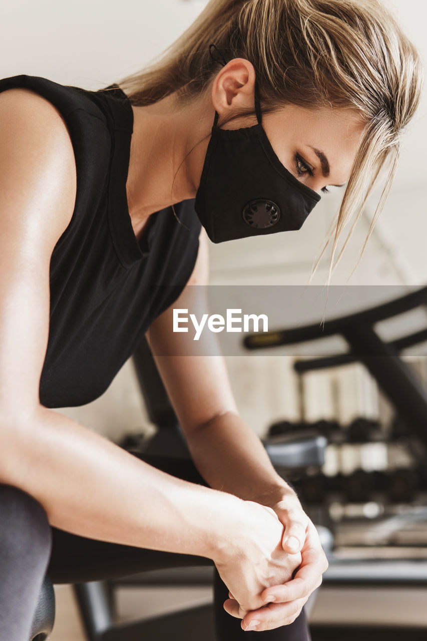 Woman wearing mask exercising at gym