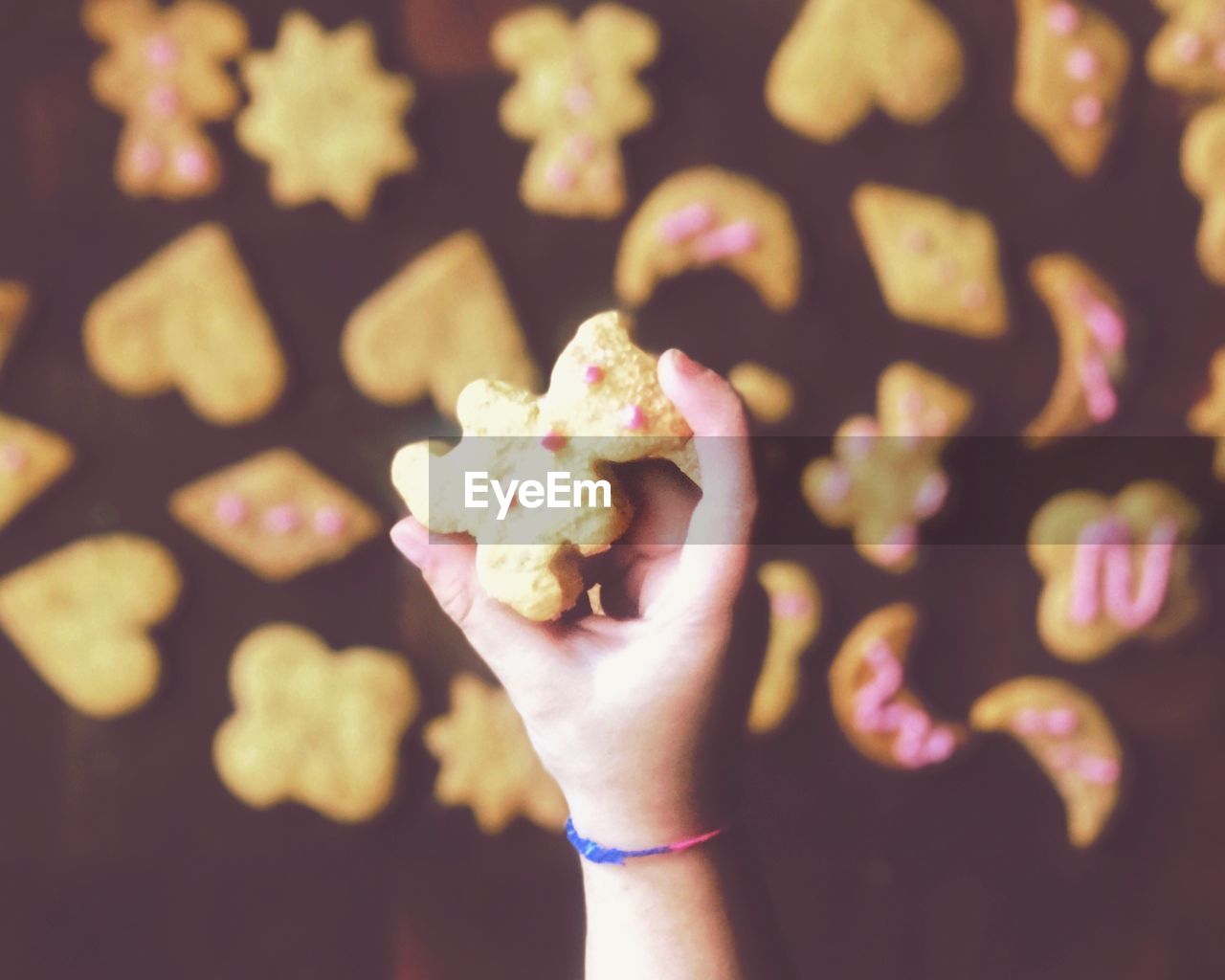 CLOSE-UP OF HAND HOLDING CAKE