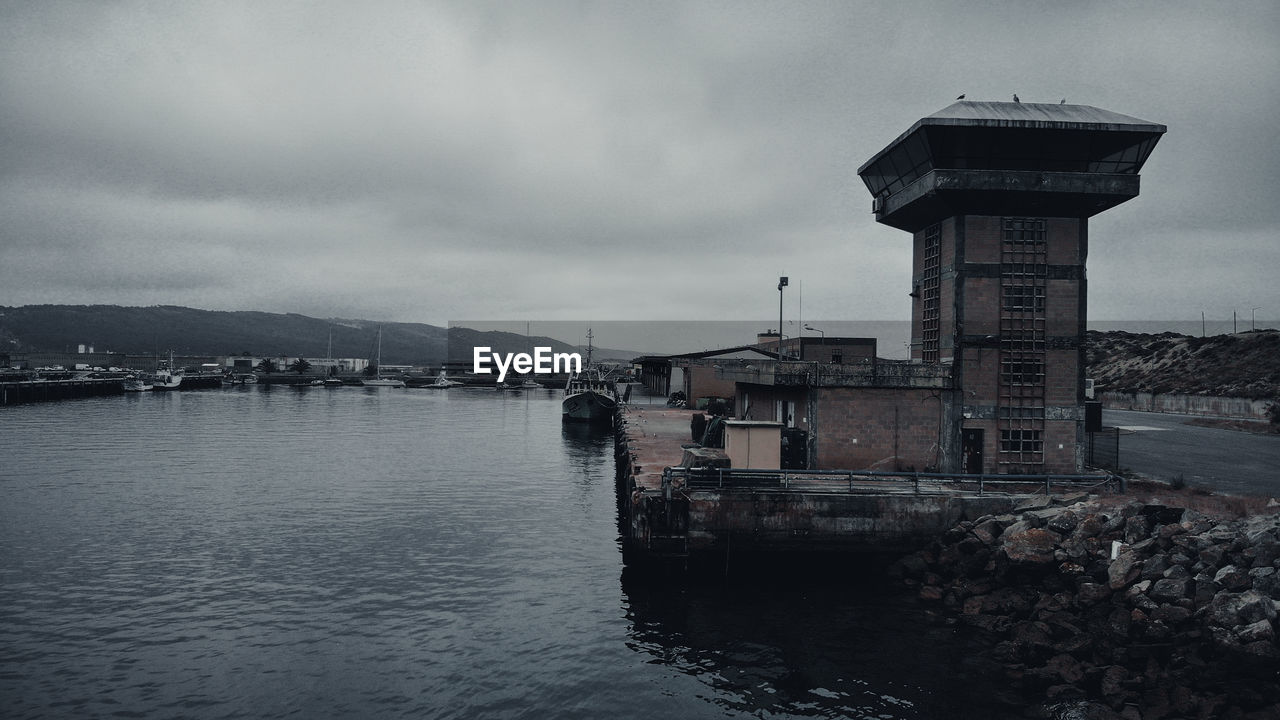 Scenic view of sea by buildings against sky