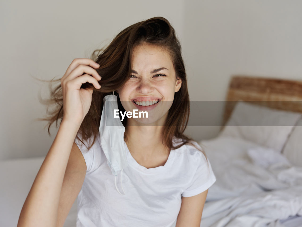 Portrait of smiling young woman relaxing on bed at home