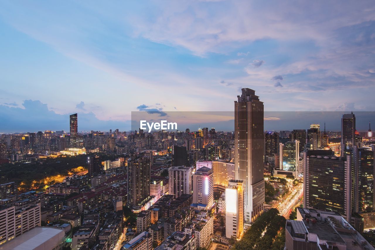 Aerial view of illuminated buildings in city against sky