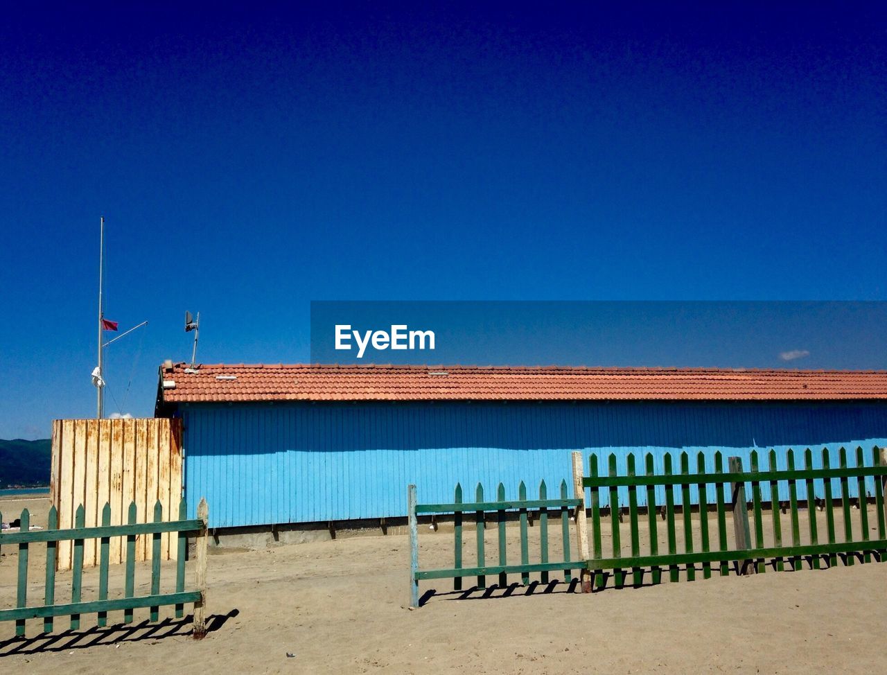 Lifeguard hut on beach against clear blue sky