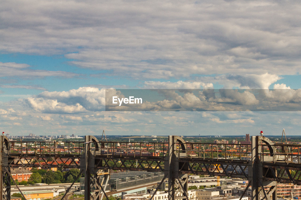 HIGH ANGLE VIEW OF BRIDGE OVER RIVER AGAINST BUILDINGS