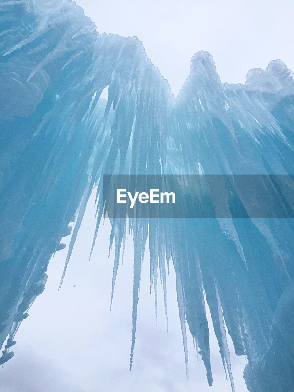 Low angle view of icicles against sky