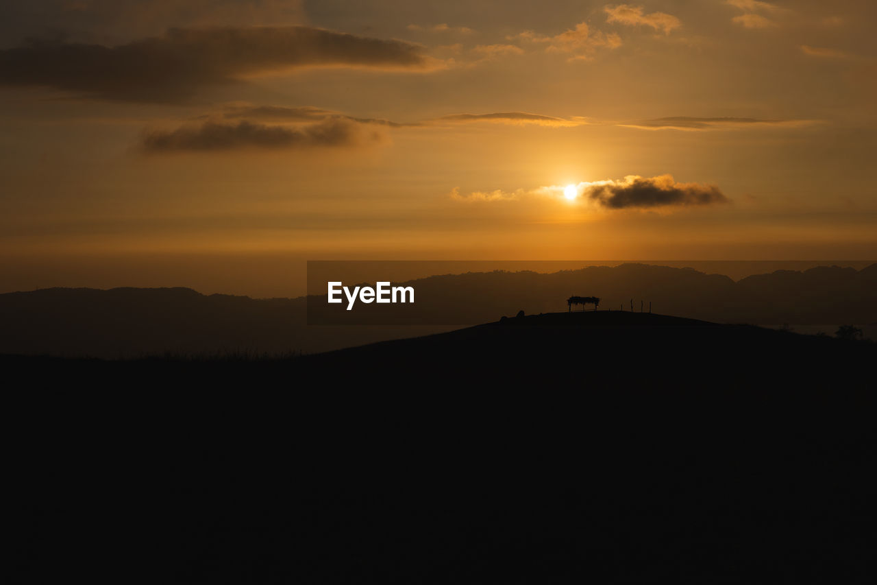 SILHOUETTE LANDSCAPE AGAINST ORANGE SKY