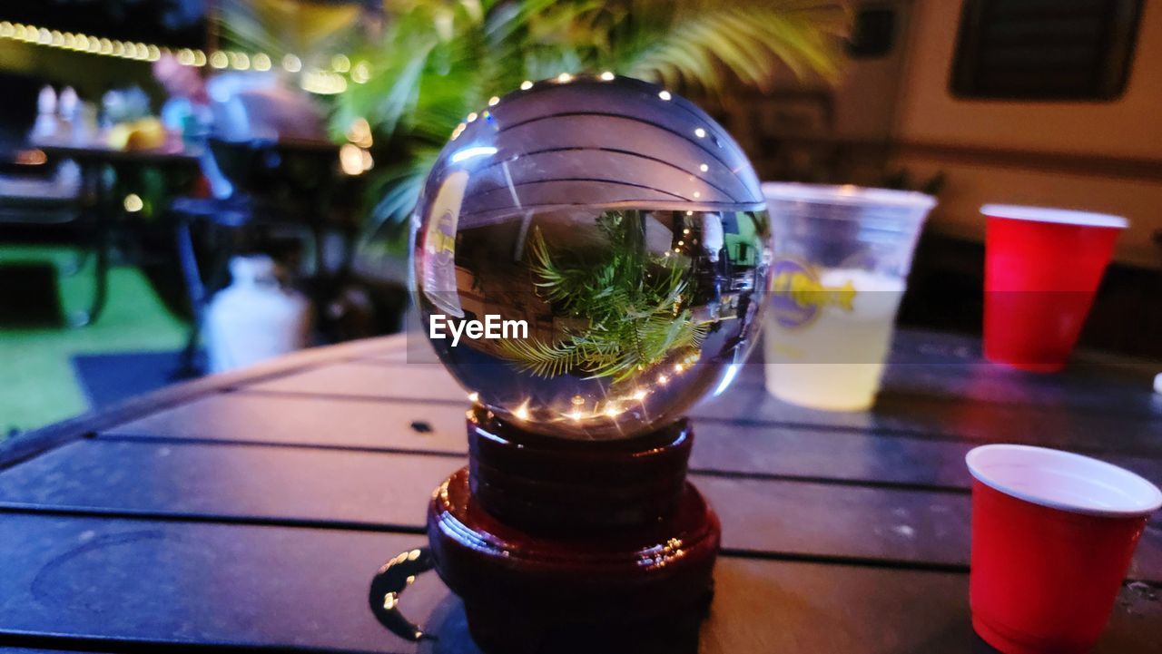 table, food and drink, drink, focus on foreground, refreshment, glass, no people, drinking glass, close-up, household equipment, lighting, blue, nature, freshness, outdoors, plant, food