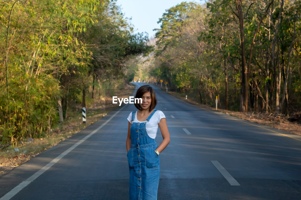Portrait of woman standing on road 