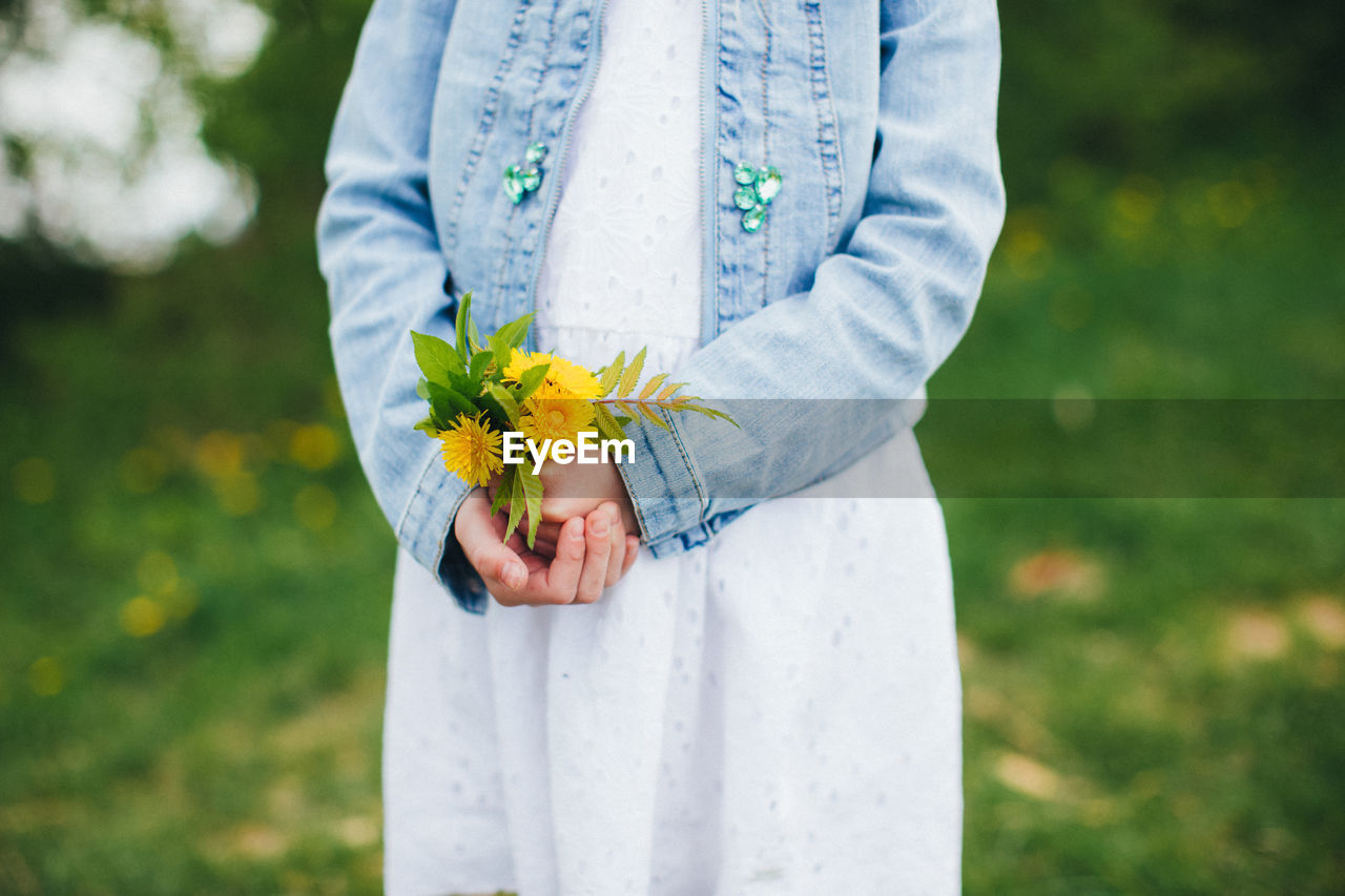 Small girl is holding yellow chamomile flowers. high quality photo