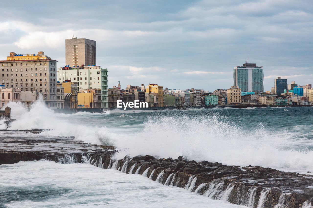 Scenic view of sea by buildings against sky