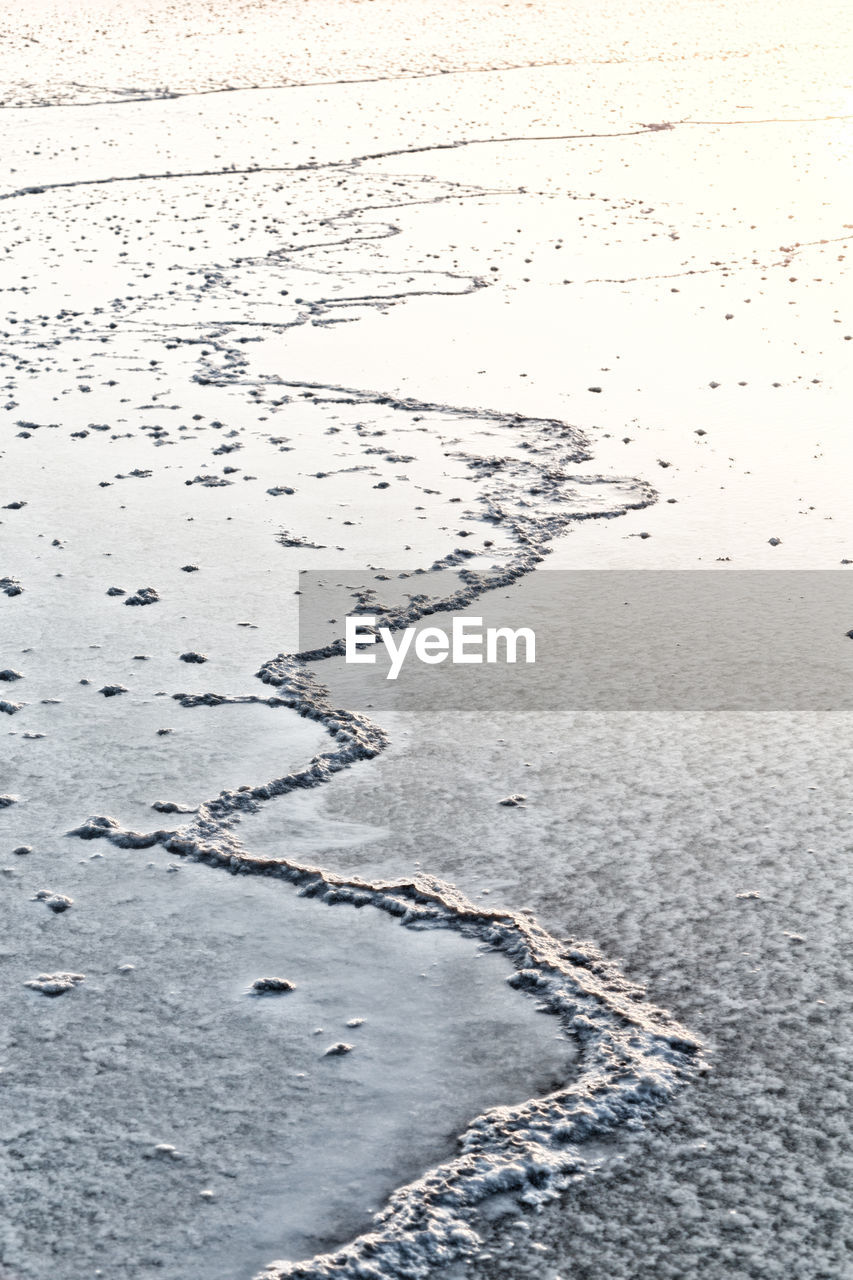 HIGH ANGLE VIEW OF FOOTPRINT ON FROZEN LAND