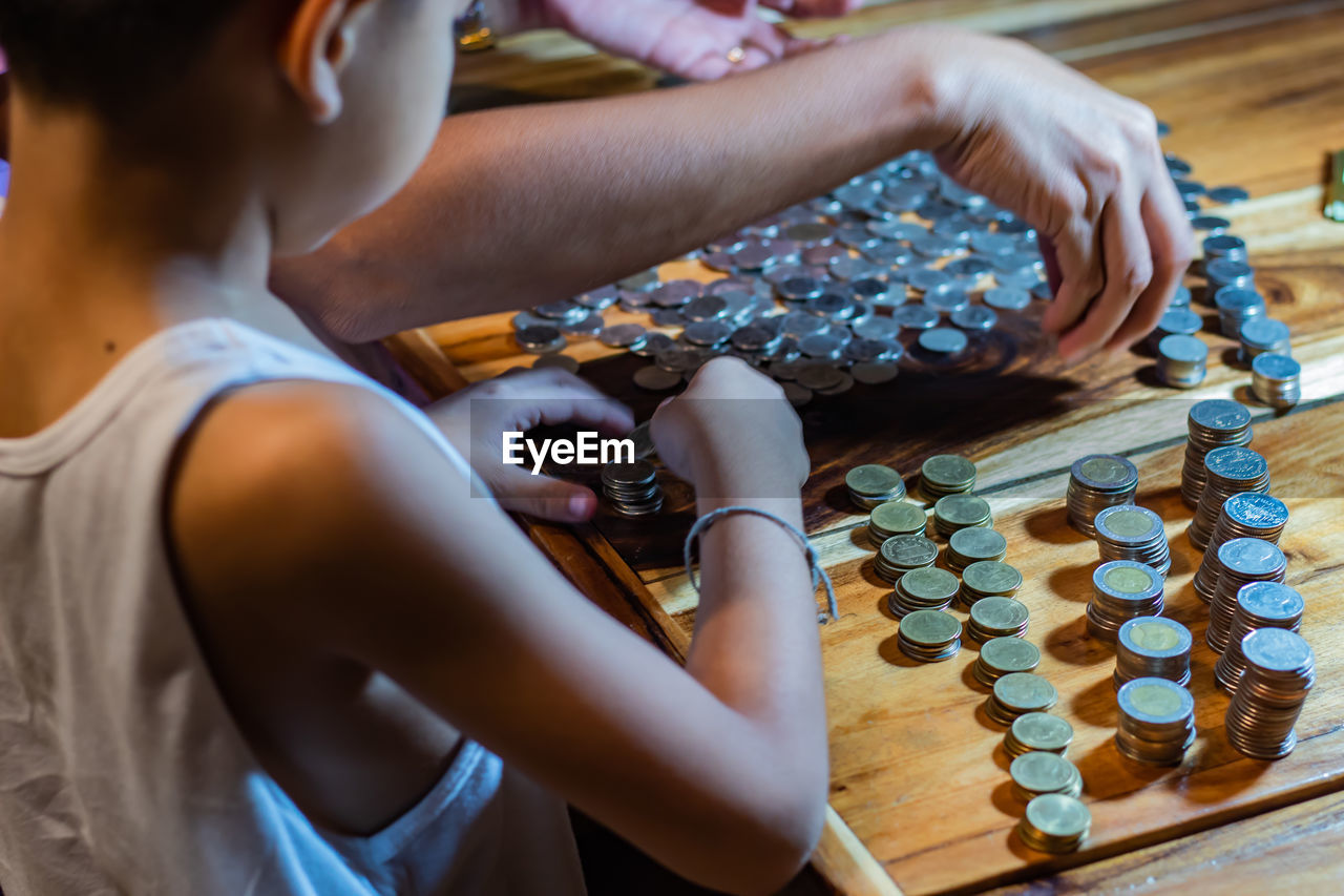 Boy stacking coins on table