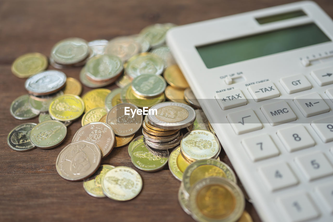 Close-up of coins and calculator on table