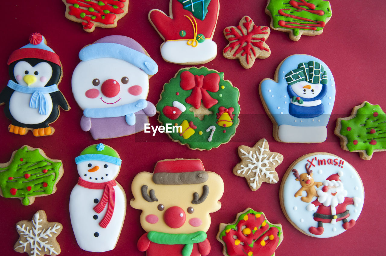 Multi colored gingerbread cookies during christmas on red background