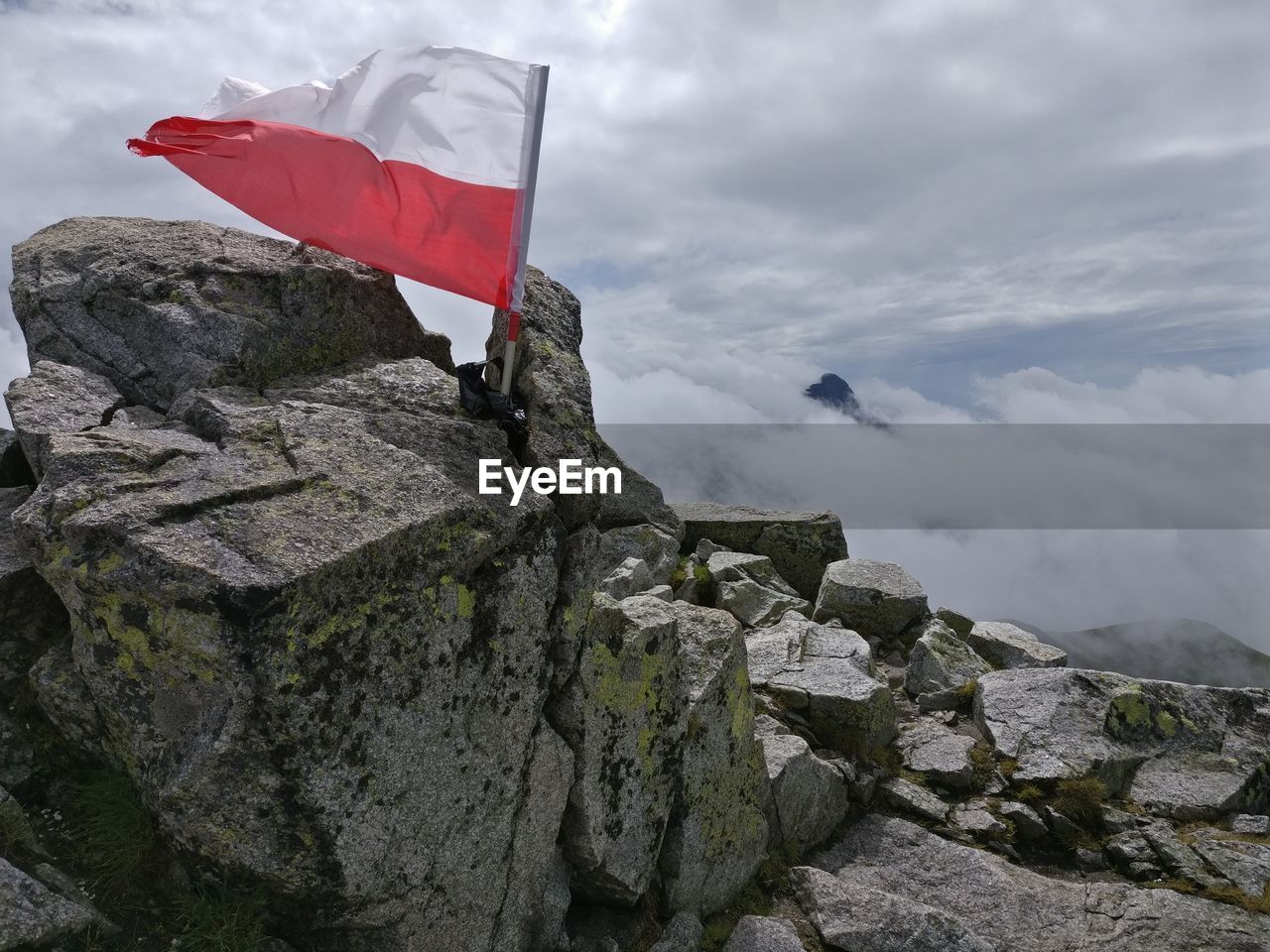 LOW ANGLE VIEW OF FLAGS AGAINST CLOUDY SKY