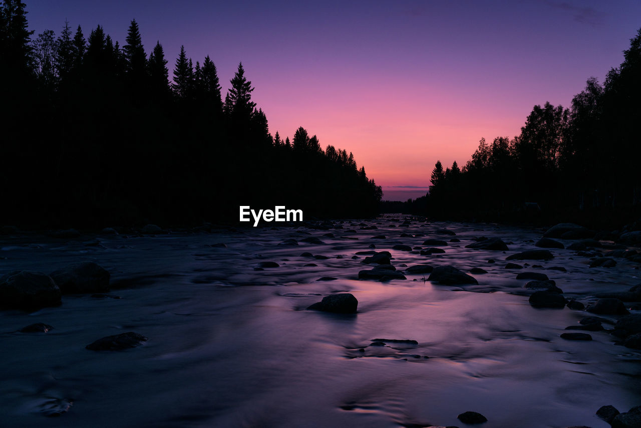 Scenic view of river against sky during sunset