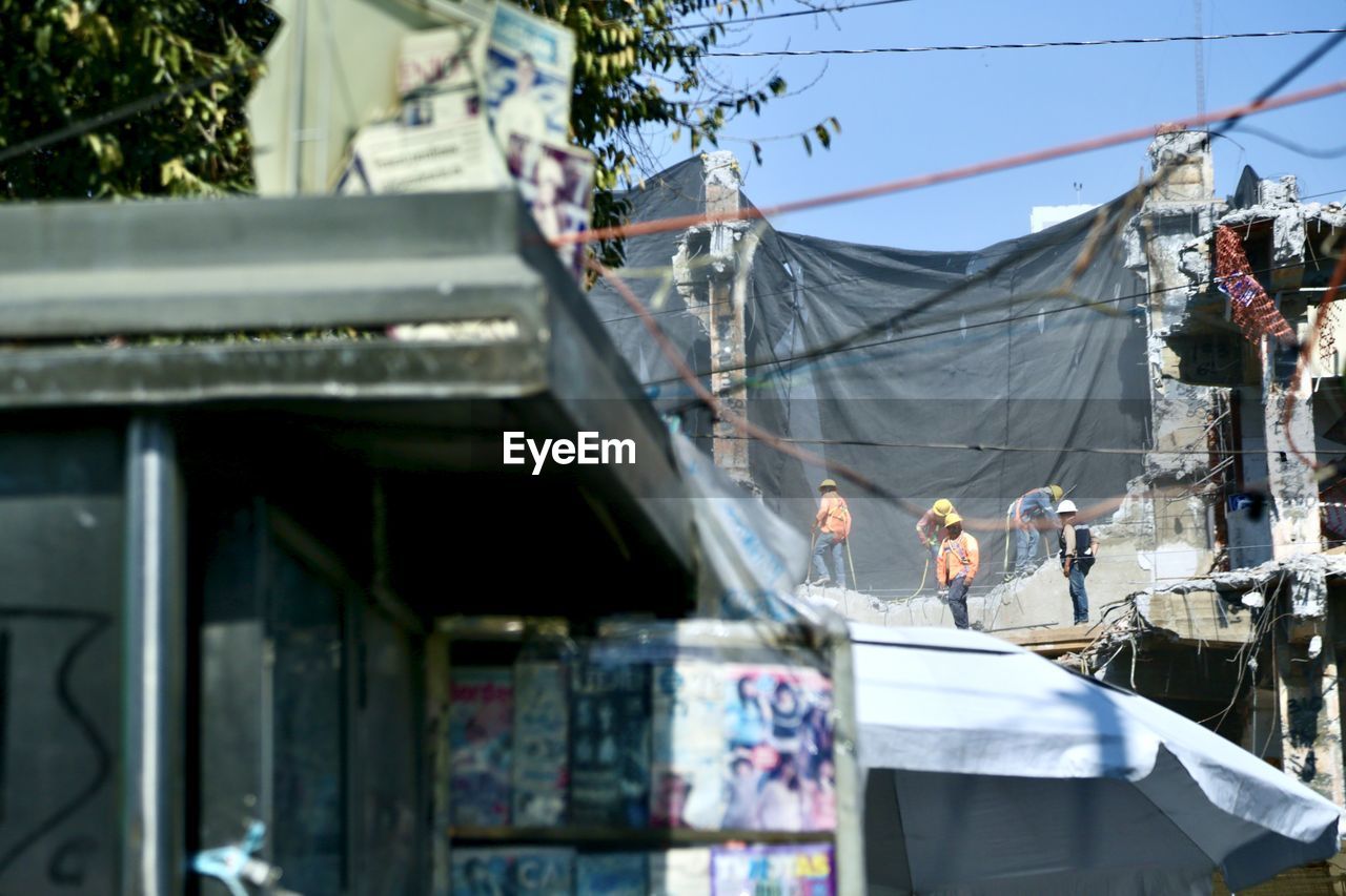 LOW ANGLE VIEW OF CLOTHES DRYING AGAINST BUILDINGS