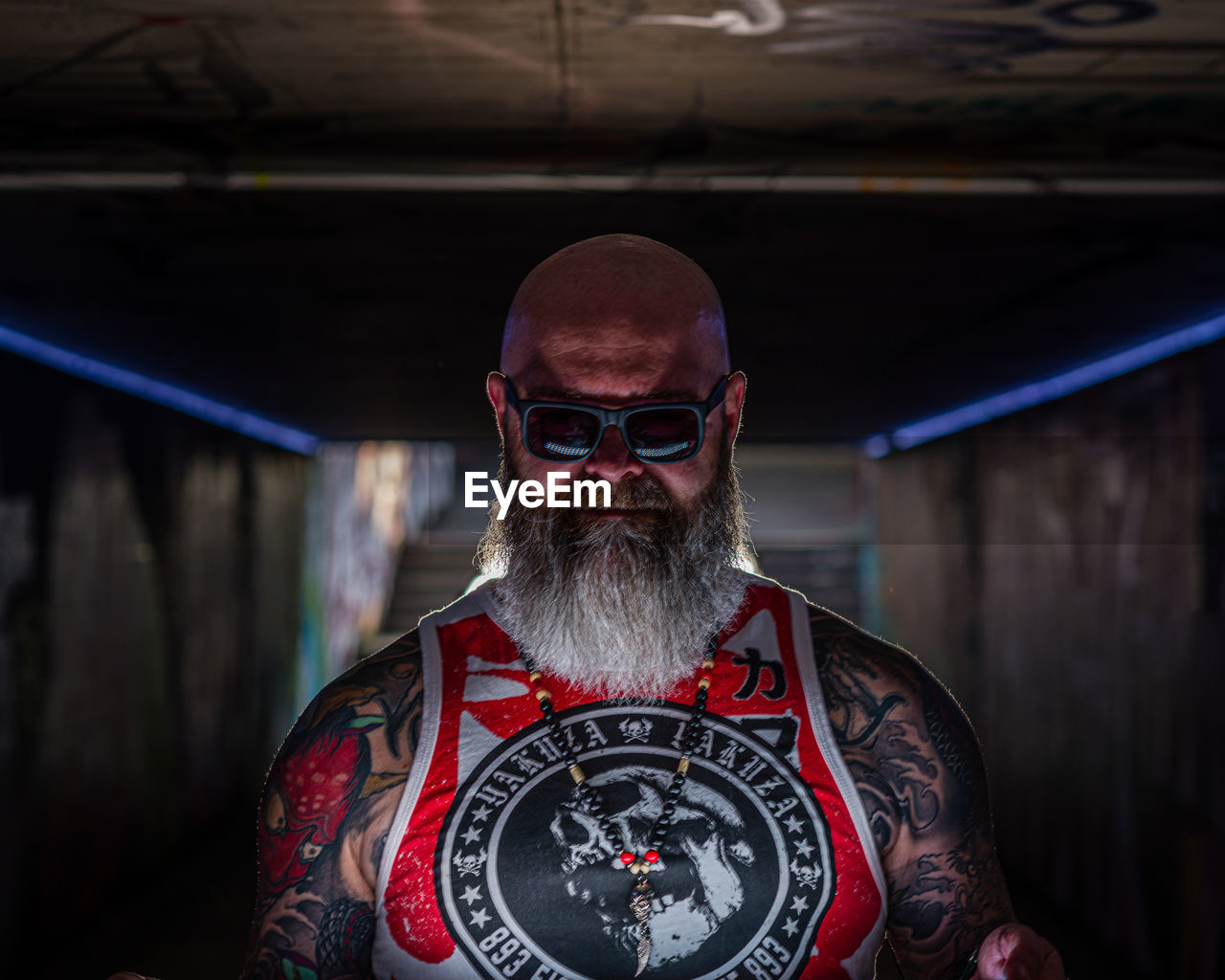 PORTRAIT OF MAN WEARING SUNGLASSES STANDING IN BATHROOM