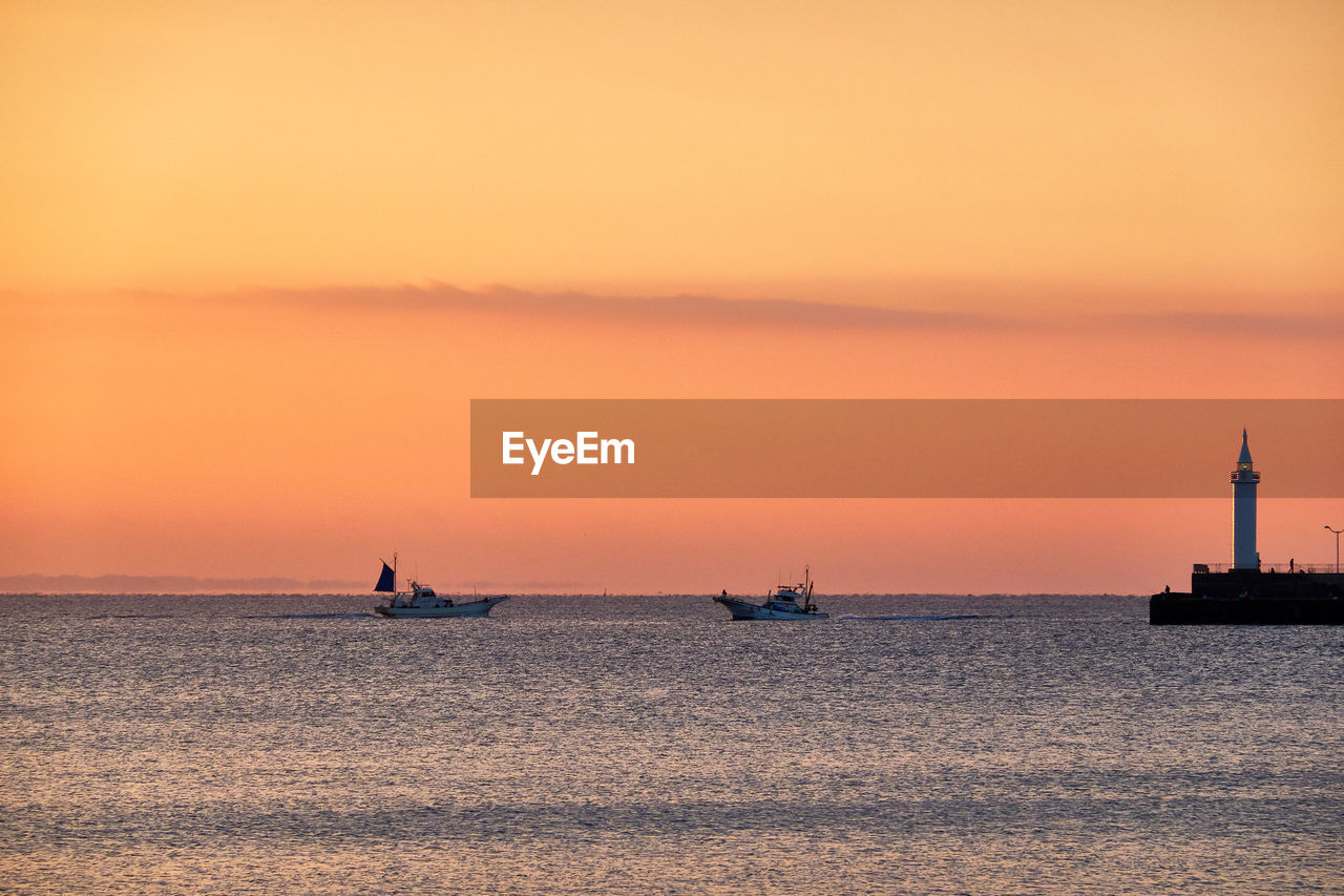 SILHOUETTE SAILBOAT IN SEA AGAINST ORANGE SKY