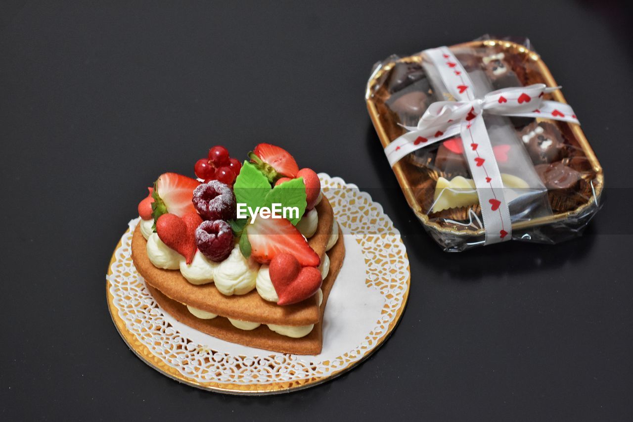 food and drink, food, dessert, fruit, sweet food, baked, berry, sweet, healthy eating, freshness, snack, studio shot, plate, cake, strawberry, sweetness, icing, pastry, indoors, no people, meal, black background, birthday cake, high angle view, still life