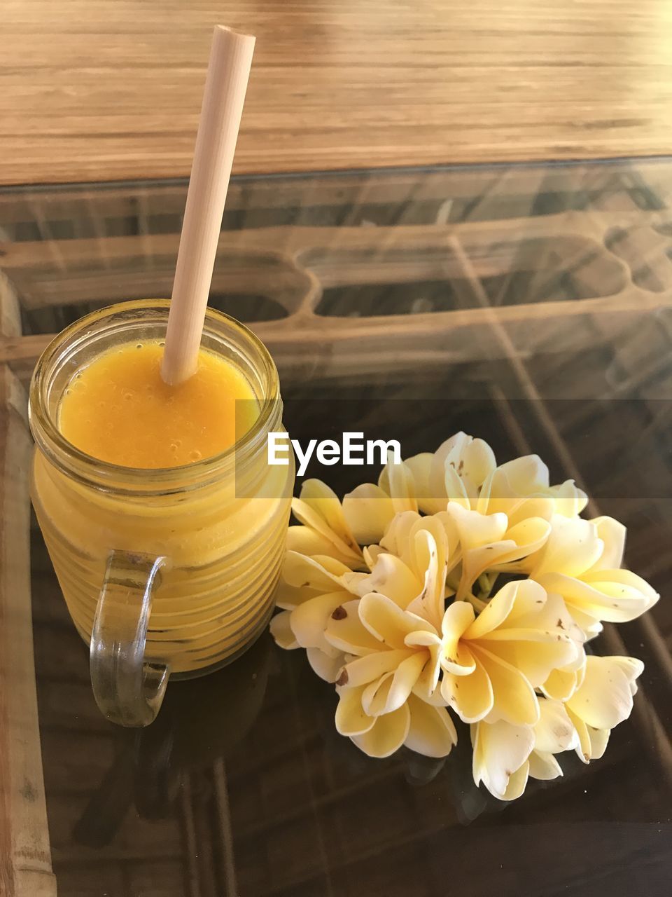 High angle view of yellow drink in glass on table