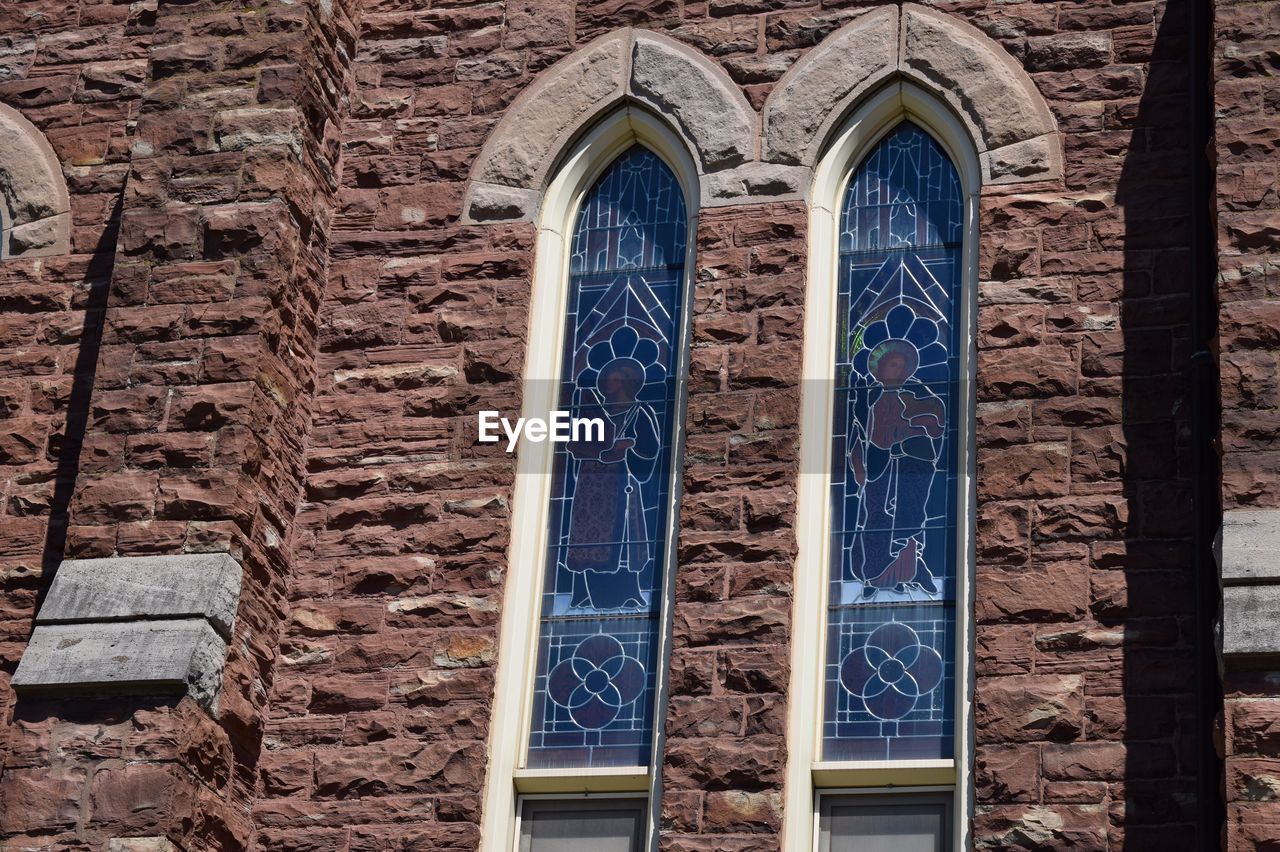 LOW ANGLE VIEW OF WINDOW ON BRICK WALL