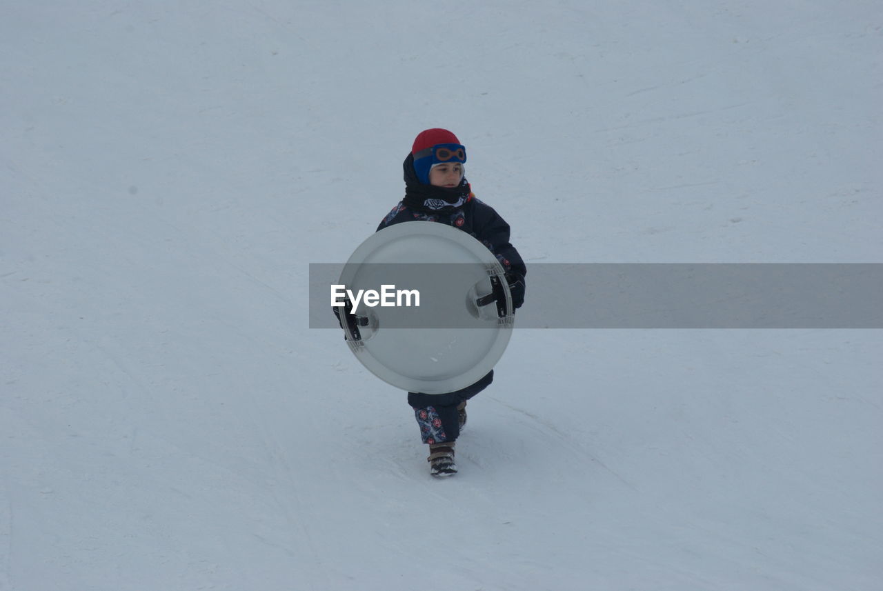 FULL LENGTH OF MAN STANDING ON SNOWY FIELD