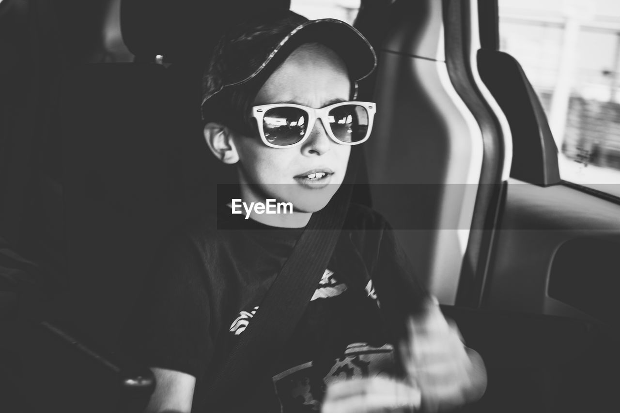 Portrait of boy wearing sunglasses in car