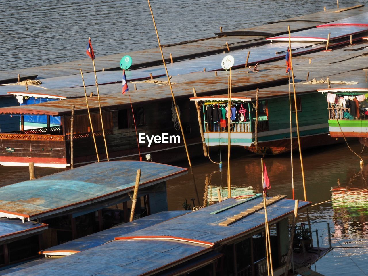 HIGH ANGLE VIEW OF BOATS MOORED ON LAKE BY BUILDING