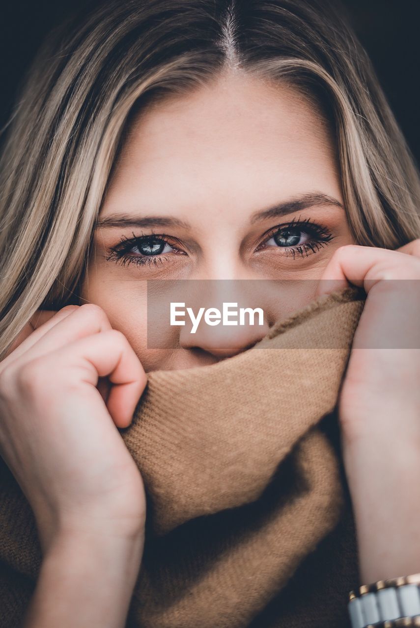 Portrait of young woman covering face with hand