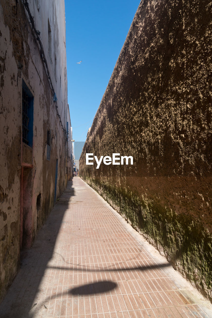 Narrow alley between old buildings and older city wall, in the medina of essaouira, morocco